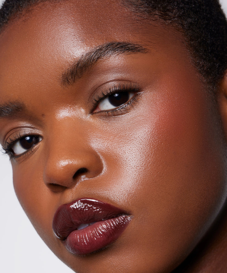 | desc: | text: light Model wears Lip Gloss in Plum